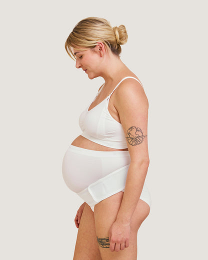 Gravid kvinna med Carriwell stödbälte i vitt sett från sidan