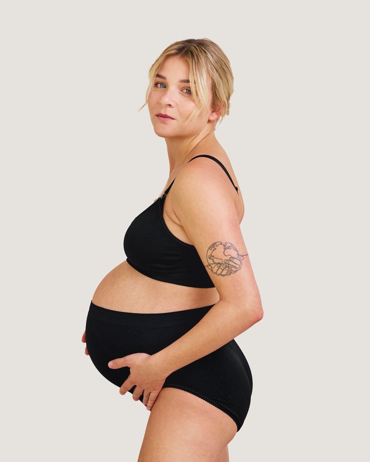 Gravid kvinna med Carriwell stödtrosa i svart sett från sidan